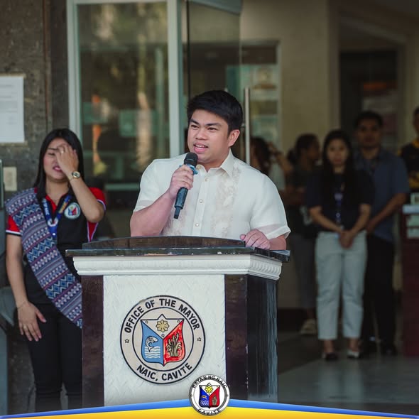 Mayor na nagsasalita sa mikropono sa podium habang nasa flagraising ceremony ng Bayan ng Naic, Cavite