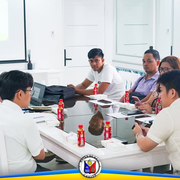 Pulong ng Local School Board sa Naic Municipal Hall, may mga kalahok na nakaupo sa mahabang mesa habang nag-uusap