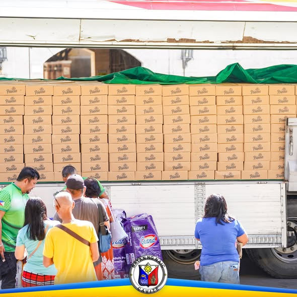 Mga tao na kumukuha ng relief goods mula sa trak sa Naic Town Plaza