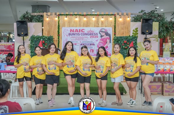 Mga kalahok sa Naic Buntis Congress 2026 na nakapila at nagpo-pose habang hawak ang mga supot sa harap ng entablado