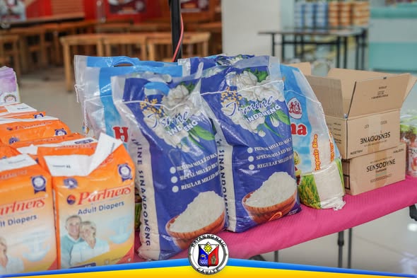 Mga supot ng bigas, adult diapers, at kahon ng gamot sa mesa sa Naic Buntis Congress 2026
