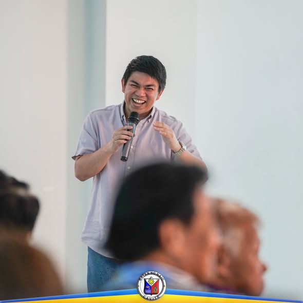 Nagsasalita ang isang lalaki gamit ang mikropono sa Mid-Year Evaluation ng Senior Citizens Program sa Naic
