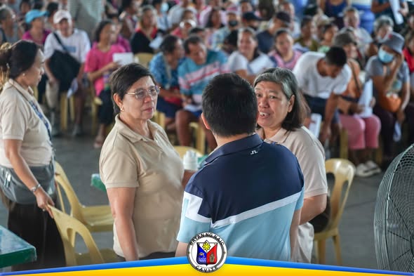 Mga dumalo at kawani habang nagsasagawa ng pamamahagi ng tulong sa Naic Town Plaza