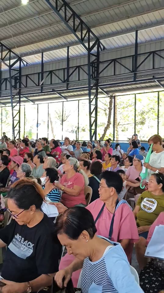 Mga tao sa covered court ng Timalan Balsahan habang dumadalo sa Localized Social Pension Plan.