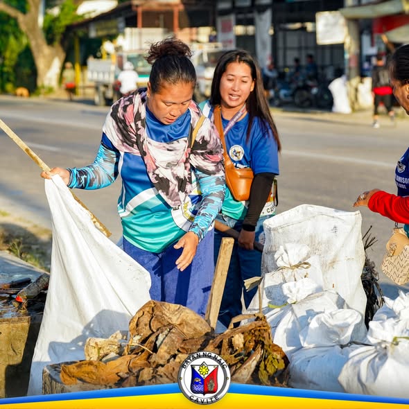 Mga boluntaryo habang naglalagay ng basura at dahon sa sako sa gilid ng kalsada sa Brgy. Sabang