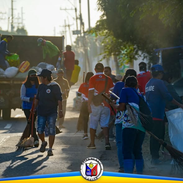 Mga boluntaryo at kawani na naglilinis ng kalsada gamit ang walis sa Brgy. Sabang, Naic, Cavite