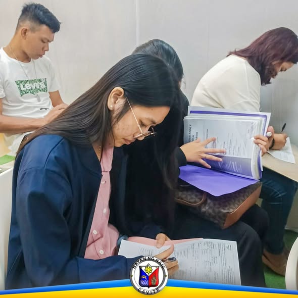 Mga aplikante na nagsasagot ng mga papel sa Local Recruitment Activity sa Waltermart Sabang, Naic