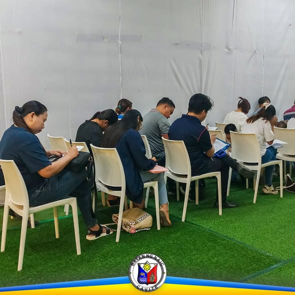 Mga aplikante na nagbabasa at nagsasagot ng papeles sa Local Recruitment Activity sa Waltermart Sabang