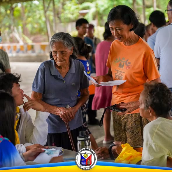 Mga senior citizen at kawani habang nagbibigay ng pension sa covered area ng barangay