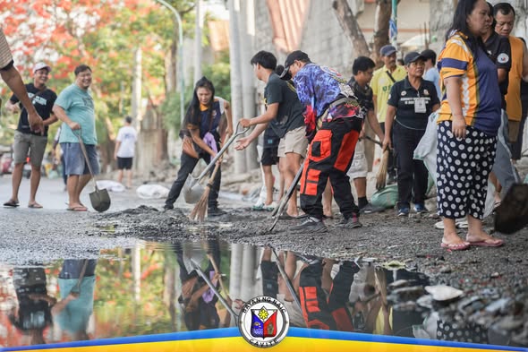 Mga residente at kawani na naglilinis ng kalsada gamit ang pala at walis sa Ciudad Nuevo Phase 3, Naic
