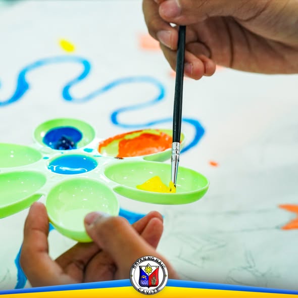 Batang nagpipinta gamit ang brotse sa canvas sa Canvas Painting Contest ng BFP Naic