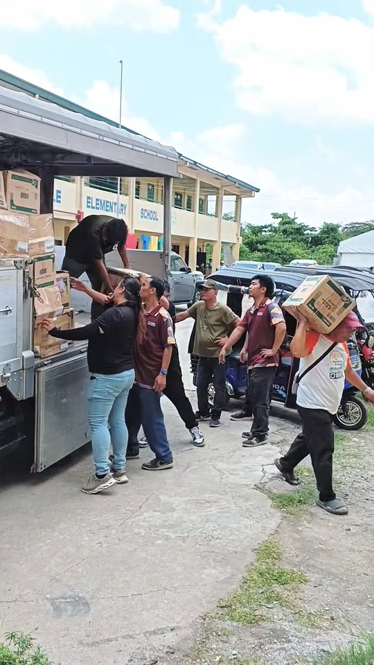 Mga tao habang nagbababa ng mga kahon ng school supplies sa Timalan Hillsview Elementary School