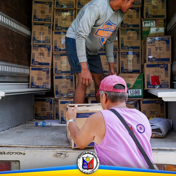 Mga tao naglilipat ng mga kahon ng school supplies sa loob ng trak bago ang pamamahagi sa Naic NHS.