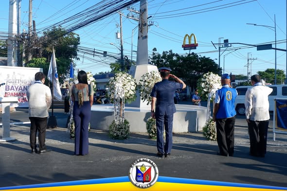 Seremonya sa Araw ng Kagitingan sa monumento, may lalaking nagsaludo at mga floral arrangement sa Naic