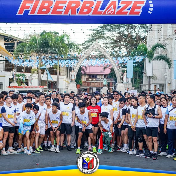 Mga kalahok na nagtitipon sa simula ng Pawikan Color Run sa ilalim ng FIBERBLAZE na banner sa Naic