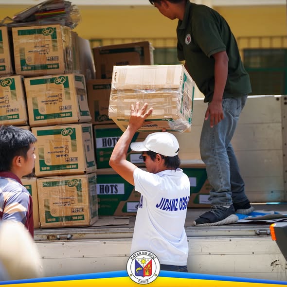 Mga tauhan ng munisipyo habang nagbubuhat ng mga kahon ng school supplies mula sa truck
