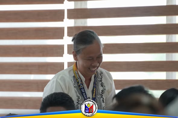 Isang babaeng nakangiti habang dumadalo sa pulong ng Naic Performance Management Team sa munisipyo