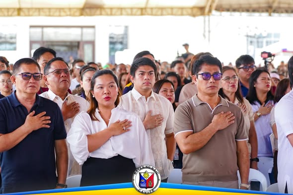 Mga dumalo na nakatayo at nakahawak sa dibdib habang nag-aawit ng pambansang awit sa programang Handog ng Pangulo