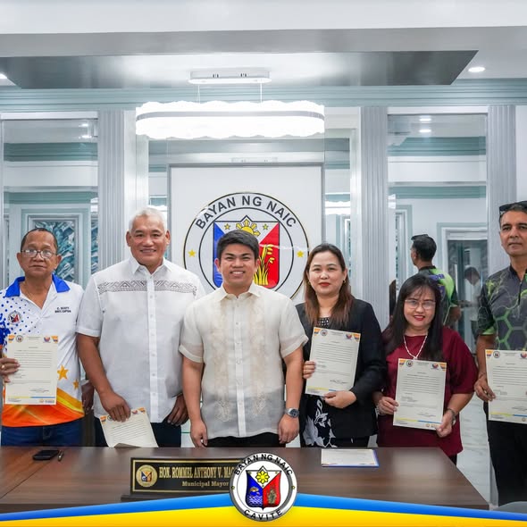 Mga bagong miyembro ng PLEB na hawak ang sertipiko sa opisina ng Bayan ng Naic, may seal ng munisipyo sa likod.