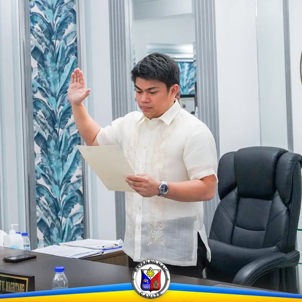 Lalaking naka-barong na nanunumpa habang hawak ang papel sa opisina ng Naic