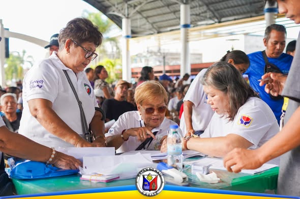 Mga kawani ng MSWDO na nag-aasikaso ng mga senior citizen sa National Social Pension sa Naic Town Plaza