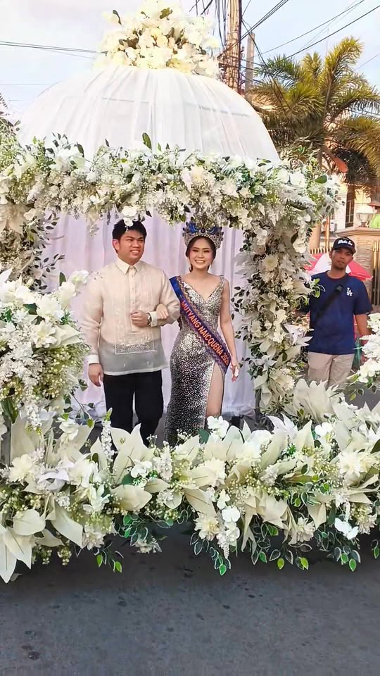 Pareha sa ilalim ng puting floral arch sa Sunduan 2026, Naic town plaza