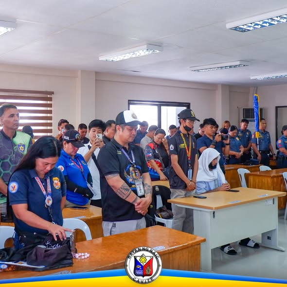 Mga pulis at dumalo na nakatayo sa ABC Hall habang isinasagawa ang turnover of command ng Naic Municipal Police Station