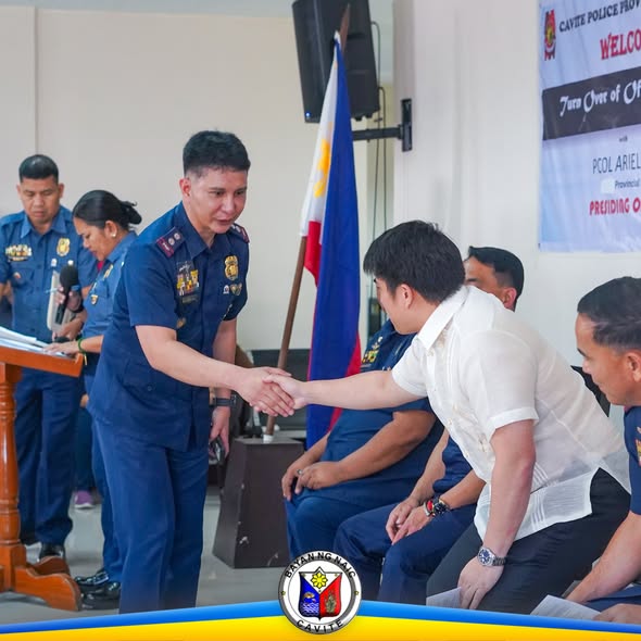 Mga pulis na nagkakamayan sa turnover of command sa loob ng hall sa Naic, Cavite