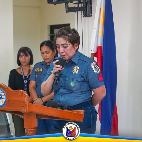 Pulis na nagsasalita sa mikropono sa podium sa turnover of command ng Naic Municipal Police Station