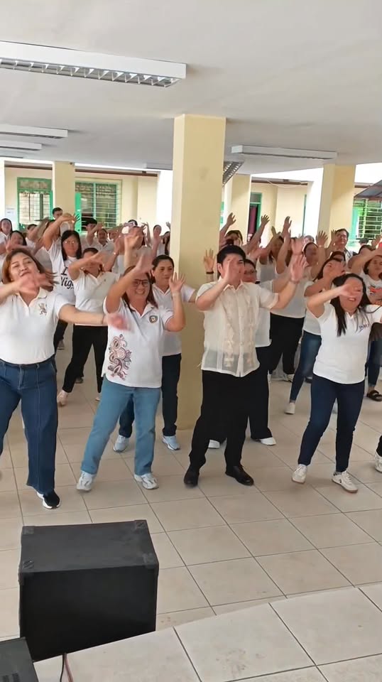 Mga kawani ng Naic District III na sumasayaw at gumagalaw nang sabay-sabay sa Brigada Eskwela sa Sabang