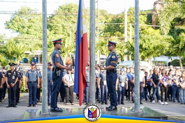 Mga uniformadong opisyal habang itinataas ang watawat sa flag raising ceremony sa Naic Municipal Hall