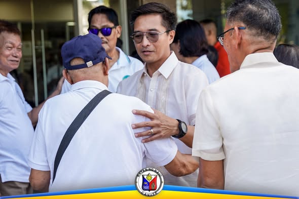 Mga kalalakihan na nagbabatian sa labas ng Naic Municipal Hall sa flag raising ceremony, Oktubre 19, 2026