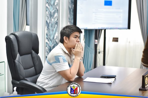 Lalaking nakaupo sa harap ng screen habang nanonood ng PDRA meeting sa opisina ng Naic, Cavite