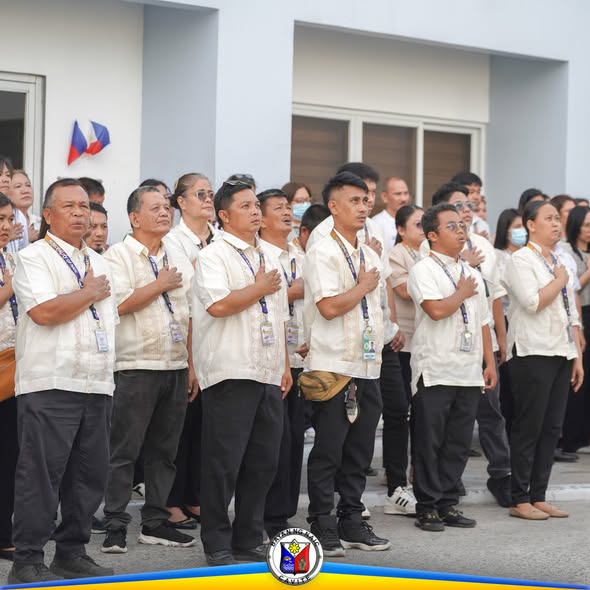 Mga kawani ng Naic Municipal Hall na nakatayo at nakahawak sa dibdib habang nag-aalay ng panunumpa sa flag raising