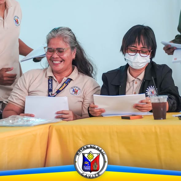 Mga kalahok ng exit conference na nagbabasa ng papeles sa mesa na may dilaw na mantel, Naic, Cavite
