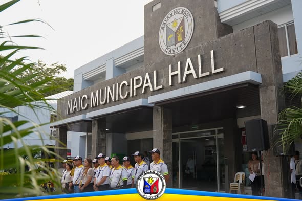 Mga kawani ng NTMO na nakahanay sa harap ng Naic Municipal Hall habang may flag raising ceremony