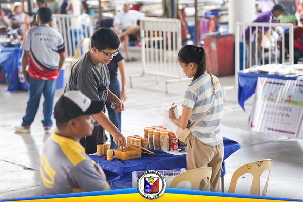 Mga mamimili sa Kadiwa ng Pangulo habang bumibili ng mga produkto sa covered court ng Naic Town Plaza
