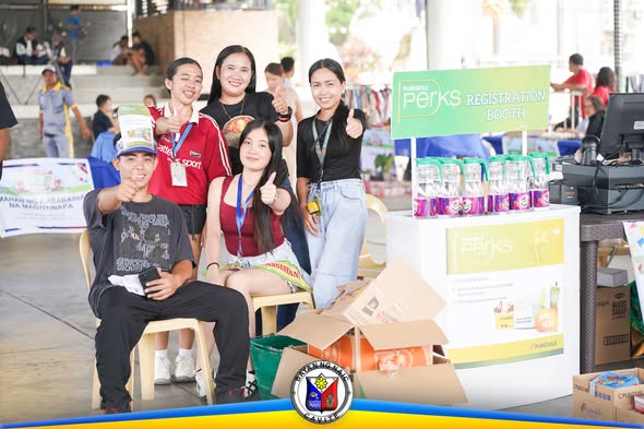 Mga tao sa Perks Registration Booth sa Kadiwa ng Pangulo sa Naic Town Plaza, nagpo-pose na naka-thumbs up