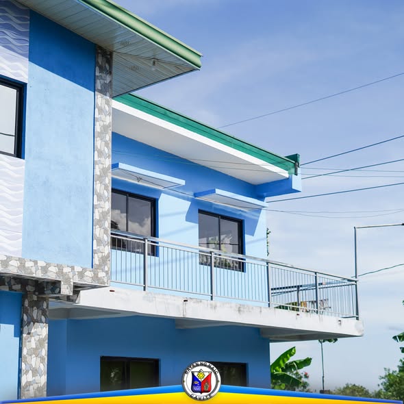 Asul na gusali ng barangay hall na may balkonahe, bahagi ng Livestock and Poultry Farmers Registration sa Palangue 2 at 3
