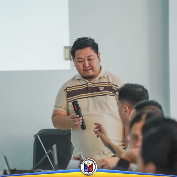 Lalaking nagsasalita gamit ang mikropono sa harap ng mga kalahok ng pagpupulong ng Receiving Local Inter-Agency Committee