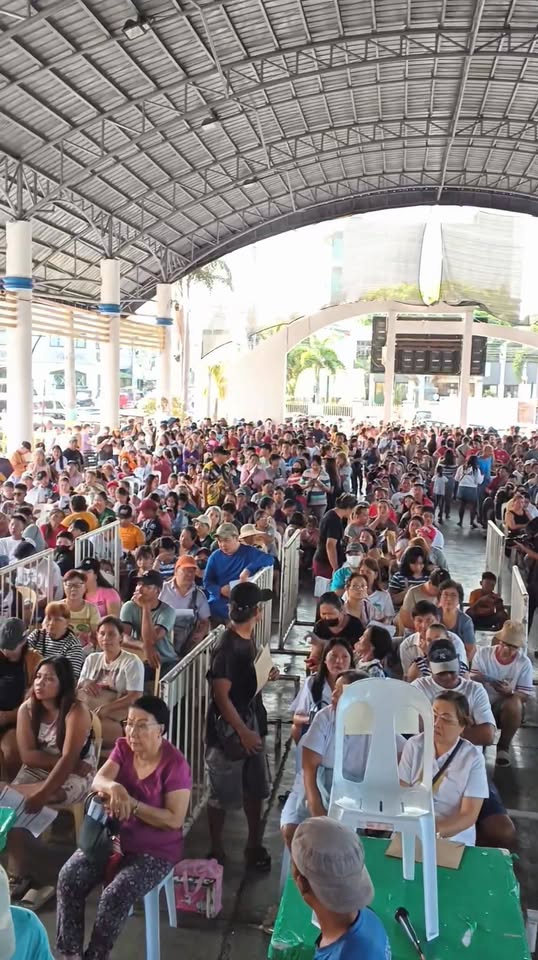 Maraming tao na naghihintay sa AICS sa covered court ng Naic Town Plaza, Marso 31, 2026