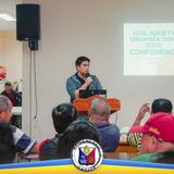 CSO Conference sa Naic: lalaking nagsasalita sa mikropono sa harap ng mga dumalo sa Liga ng mga Barangay Hall