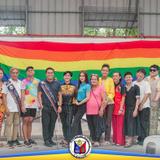 Grupo ng mga kasapi ng LGBT Pilipinas One Naic sa harap ng rainbow flag matapos ang pagpupulong at halalan