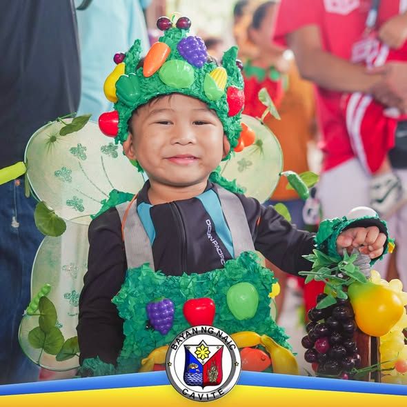 Batang nakasuot ng gulay at prutas costume habang nakangiti sa Nutrition Month celebration sa Naic