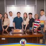 Grupo ng mga tao na nagpose sa opisina sa likod ng mahabang mesa na may plaque, Naic, Cavite