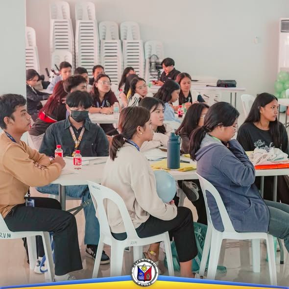 Mga kabataang dumalo sa peer facilitation training na nakaupo sa mesa sa loob ng hall sa Naic