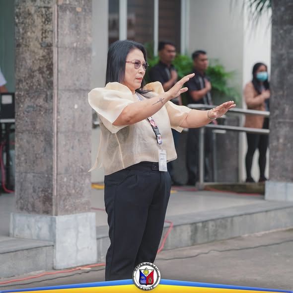 Babaeng nangunguna sa flag raising ceremony sa harap ng gusali ng Pamahalaang Bayan ng Naic