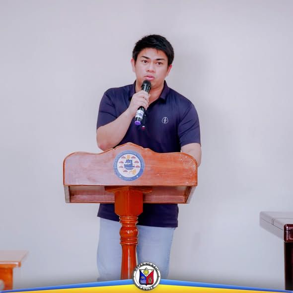 Lalaking nagsasalita sa mikropono sa podium sa harap ng pulong ng MSWM Board at Manila Bay Team sa Naic