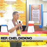 Tagapagsalita na may hawak na mikropono sa entablado ng Naic Youth Summit 2025, may caption ng broadcast sa ibaba.