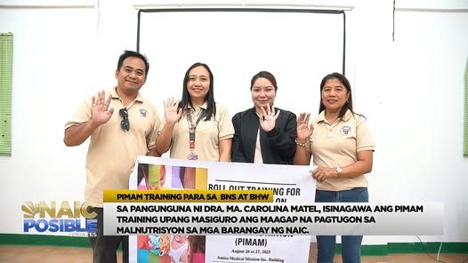 Mga kalahok at tagapagsanay ng PIMAM training na kumakaway habang may hawak na banner sa loob ng silid-pulungan
